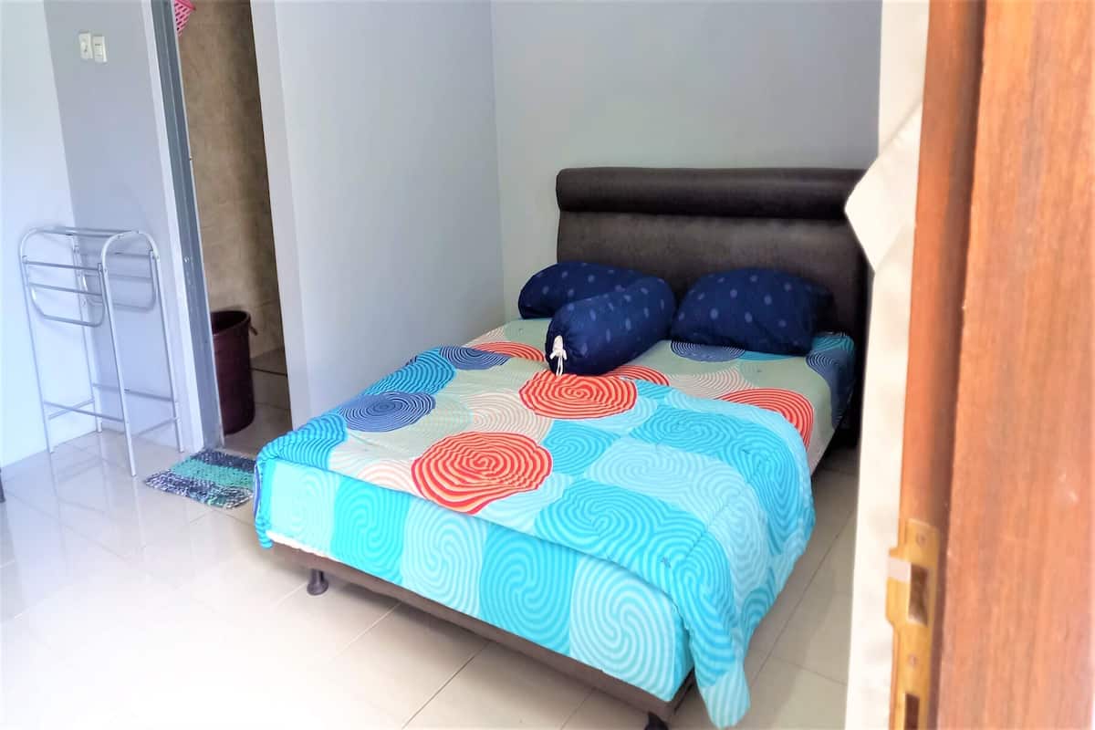 Ein Schlafzimmer mit Bett, Nachttisch und Stuhl.