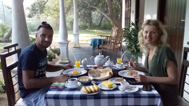 A dining area with a checkered tablecloth, plates of food, and a pitcher of orange juice. - Venus Paradise (Sigiriya)