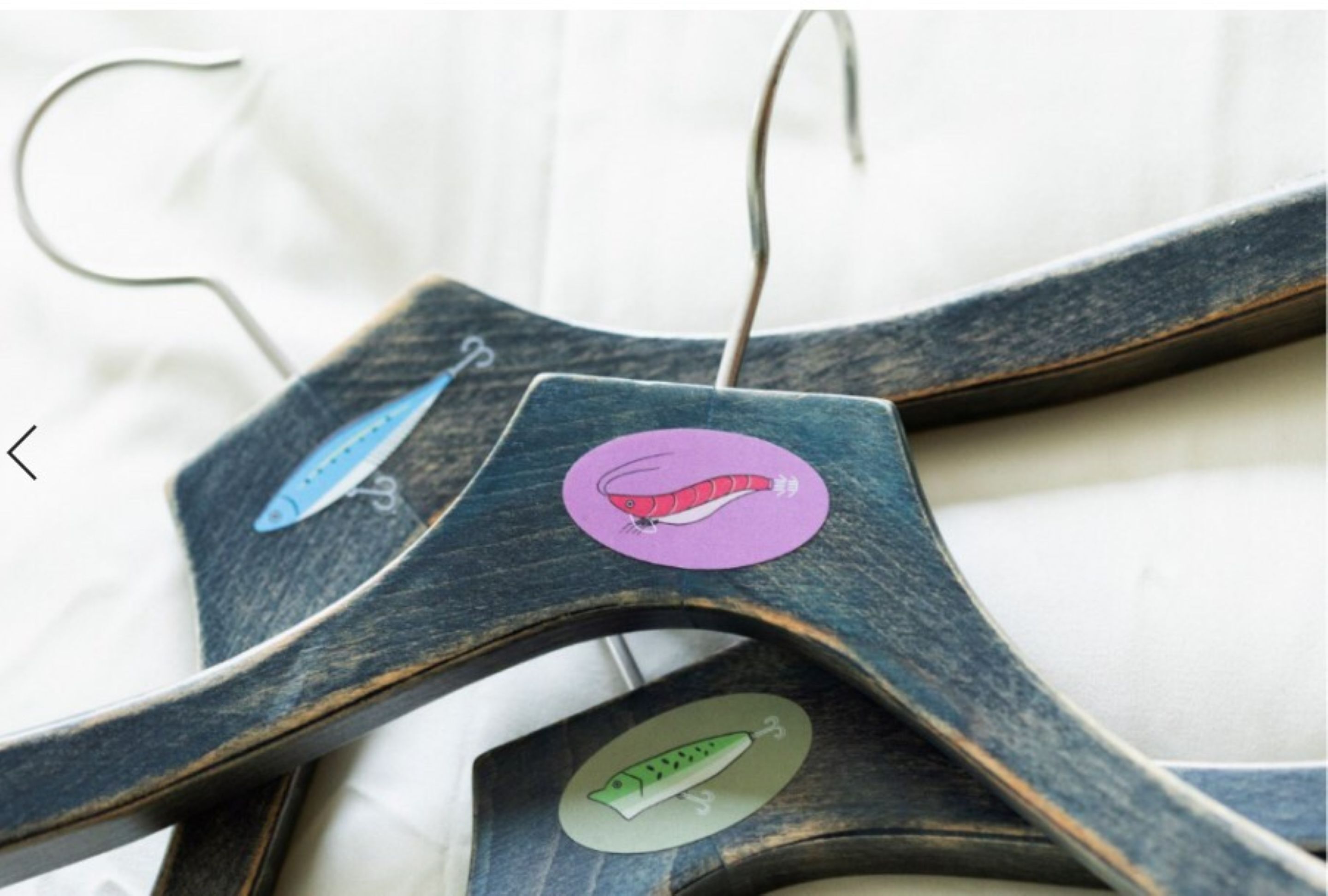A wooden hanger with a purple tag and a green tag.