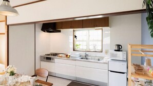 Eine moderne Küche mit weißen Schränken, einem eingebauten Backofen und einem Fenster über der Spüle.