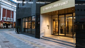 Een moderne hotelentree met een opvallend bord waarop 
