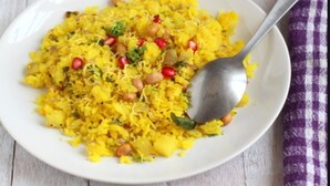 A bowl of yellow rice with chickpeas and pomegranate seeds. - Hotel Aura (Mumbai)