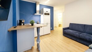 Eine moderne Küche mit Einbauofen und Mikrowelle, einer Holzausziehtafel und einer blauen Akzentwand.