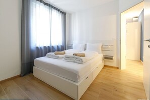 A modern hotel room with a large bed, a bedside table, and a wardrobe. - Wonderful apartment in the historic center of Merano! (Merano)