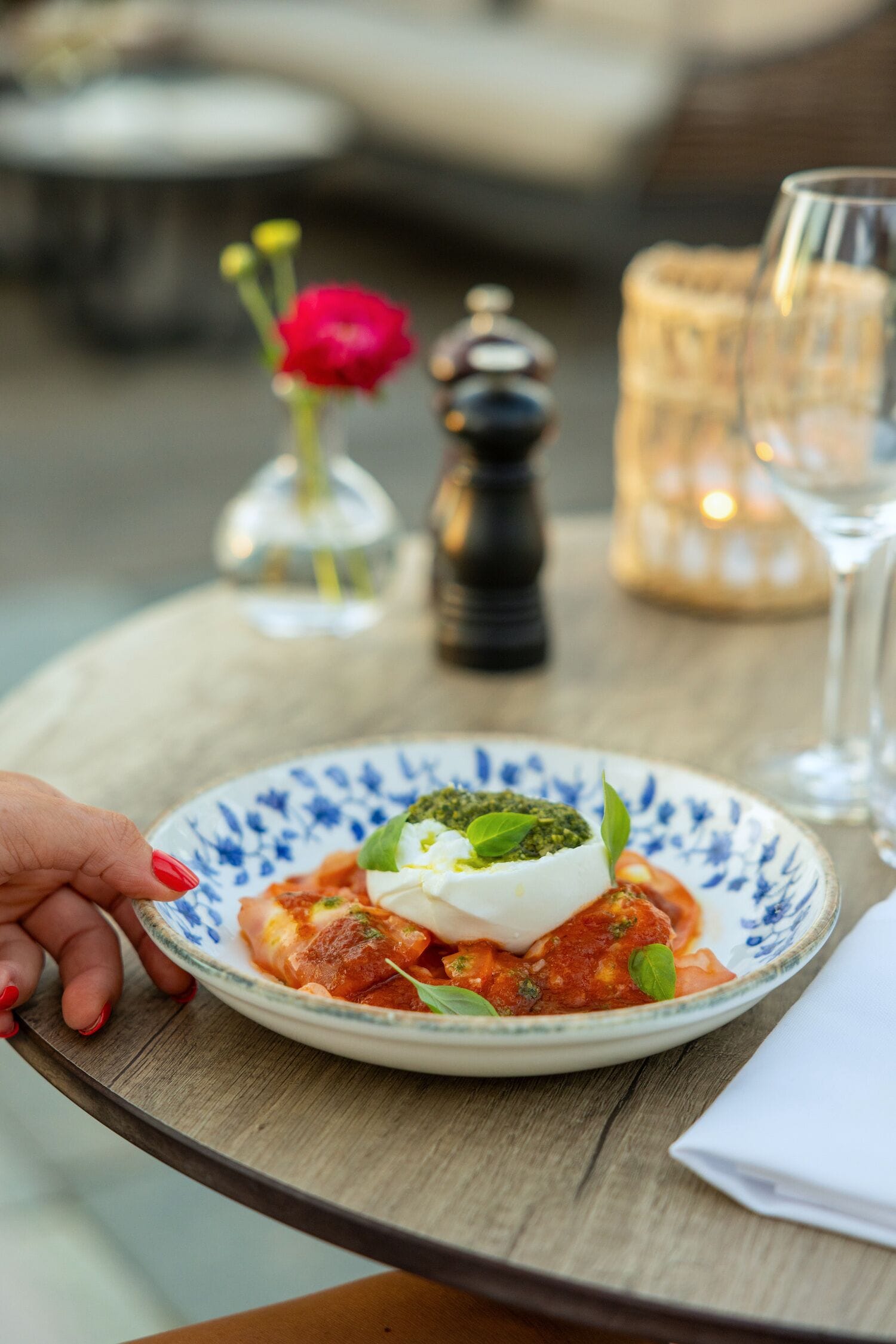 A plate of food on a table with a salt shaker and a candle in the background.