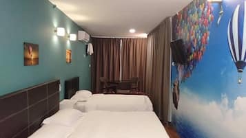 A hotel room with two beds, a desk, and a chair. There is a mural on the wall depicting hot air balloons and a ship.