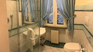 Une salle de bain avec une douche à parois de verre, des toilettes blanches et un lavabo.