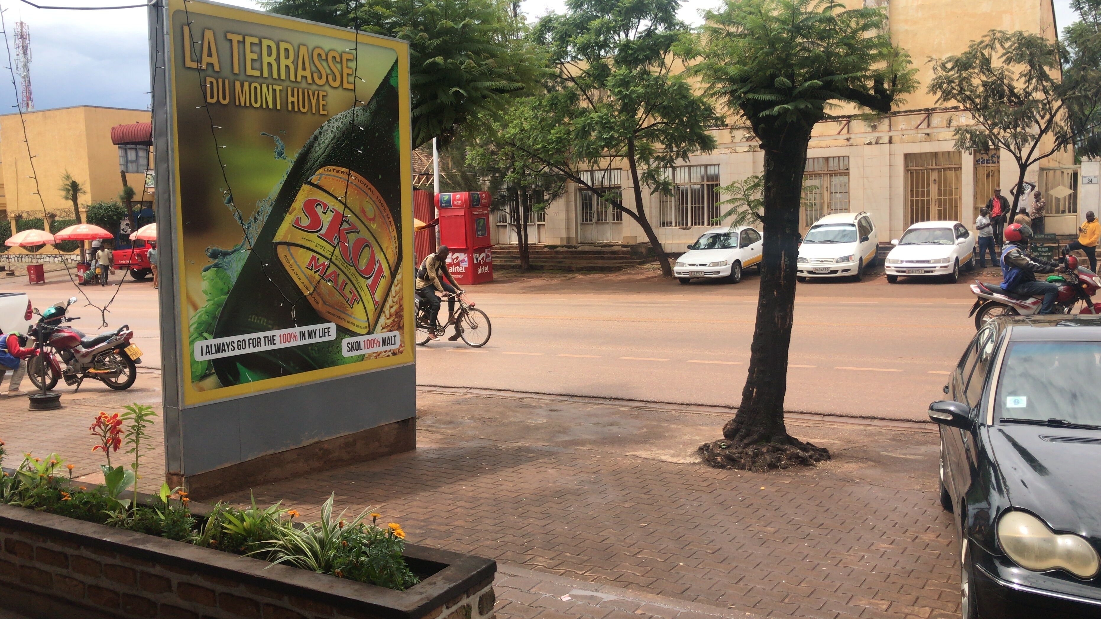 A street scene with a large advertisement for Skol malt beer.