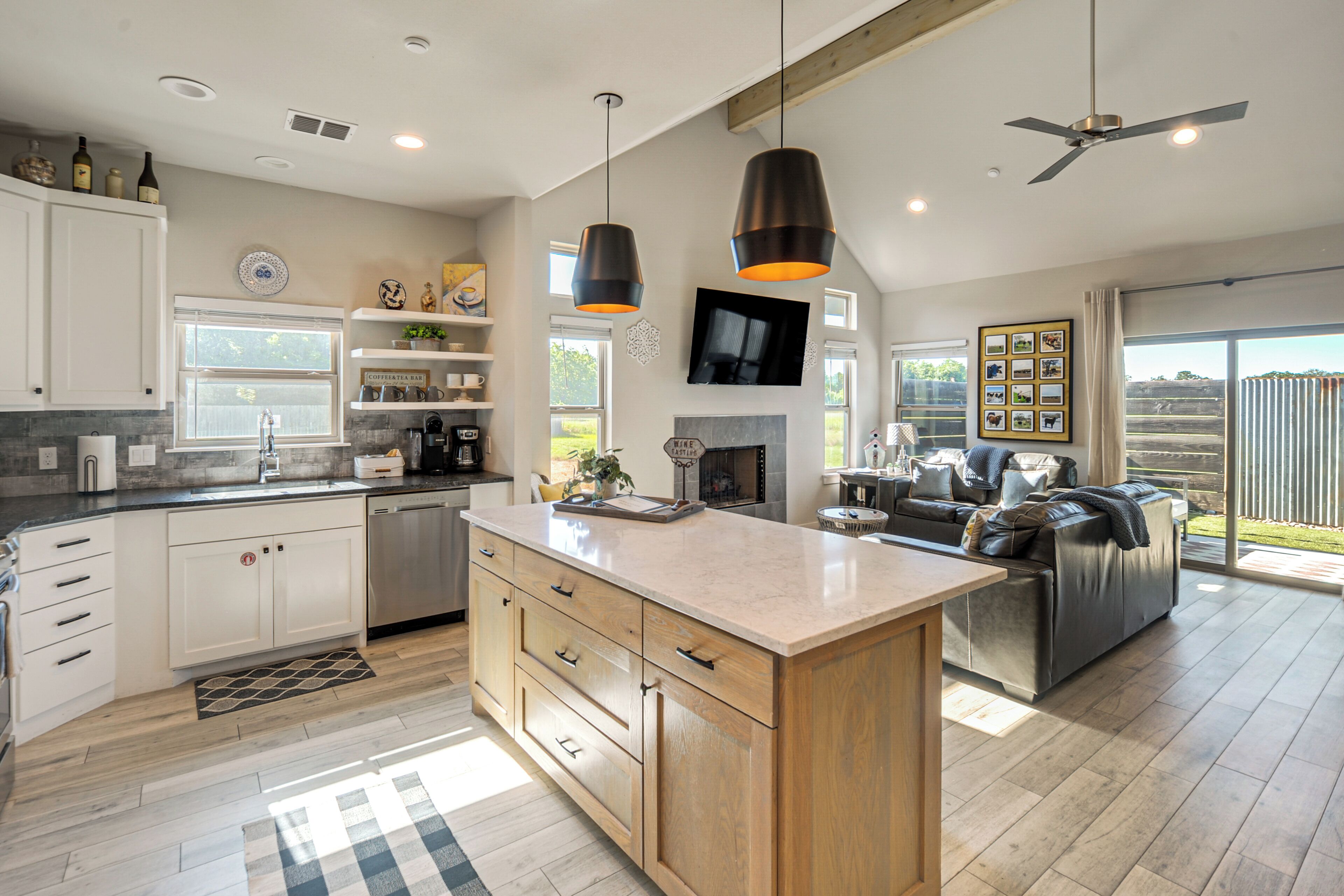 A modern kitchen with a central island, built-in cabinets, and a dining area with a sofa.