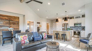 A modern living room with a leather sofa, a coffee table, and a dining area with chairs.