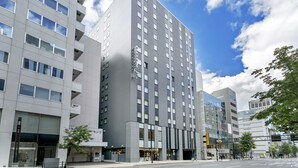 A modern hotel with a prominent vertical design, multiple floors, and a large glass facade. - JR Inn Sapporo Kita 2jo (Sapporo)