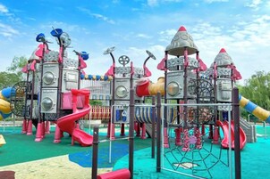 Un parque infantil con diversas estructuras de juego, incluyendo toboganes y zonas de escalada.