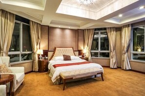 A hotel room with a large bed, bedside tables, a chair, and a view of the city at night. - City Phoenix Hotel, Europe, Country Garden, Chuzhou (Chuzhou)