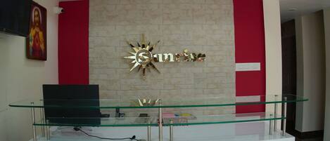 A reception desk with a glass top and a sign that reads "Sunrise".