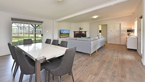 Una cocina moderna con comedor, sofá y televisor.