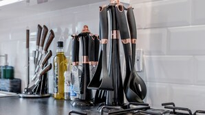 A kitchen with a gas stove, black utensils with copper handles, and a white tiled backsplash. - Stunning 2 Bedroom Duplex Apt in Center of Camden (London)