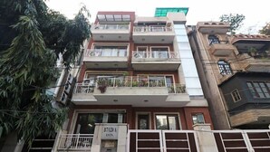 A multi-story building with balconies, a sign indicating 'B7/120 A EXTN.', and a gated entrance. - Amar Villa One (New Delhi)