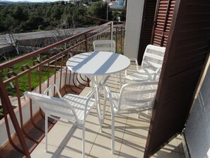 Enjoy a peaceful moment on this balcony with a table and chairs, taking in the serene views of the surrounding landscape.