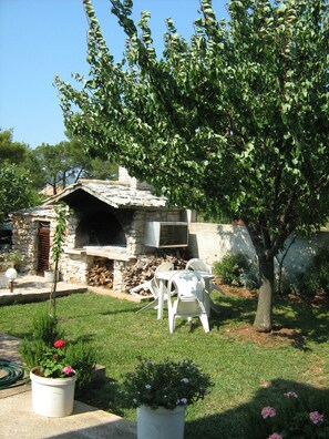 Enjoy al fresco dining and social gatherings in this charming outdoor space, complete with a barbecue area and comfortable seating.