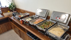 A buffet setup with various food items including eggs, ham, and vegetables. - Vanida Resort - Halal (Ayutthaya)