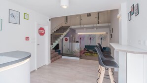 A modern interior with a reception desk, a staircase, and seating area. - Dandelion boutique hostel (Zadar)