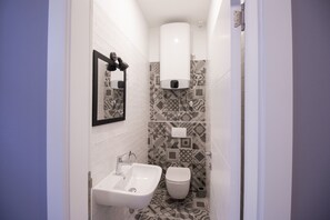 A small bathroom with a sink, toilet, and a hand dryer. - Dandelion boutique hostel (Zadar)