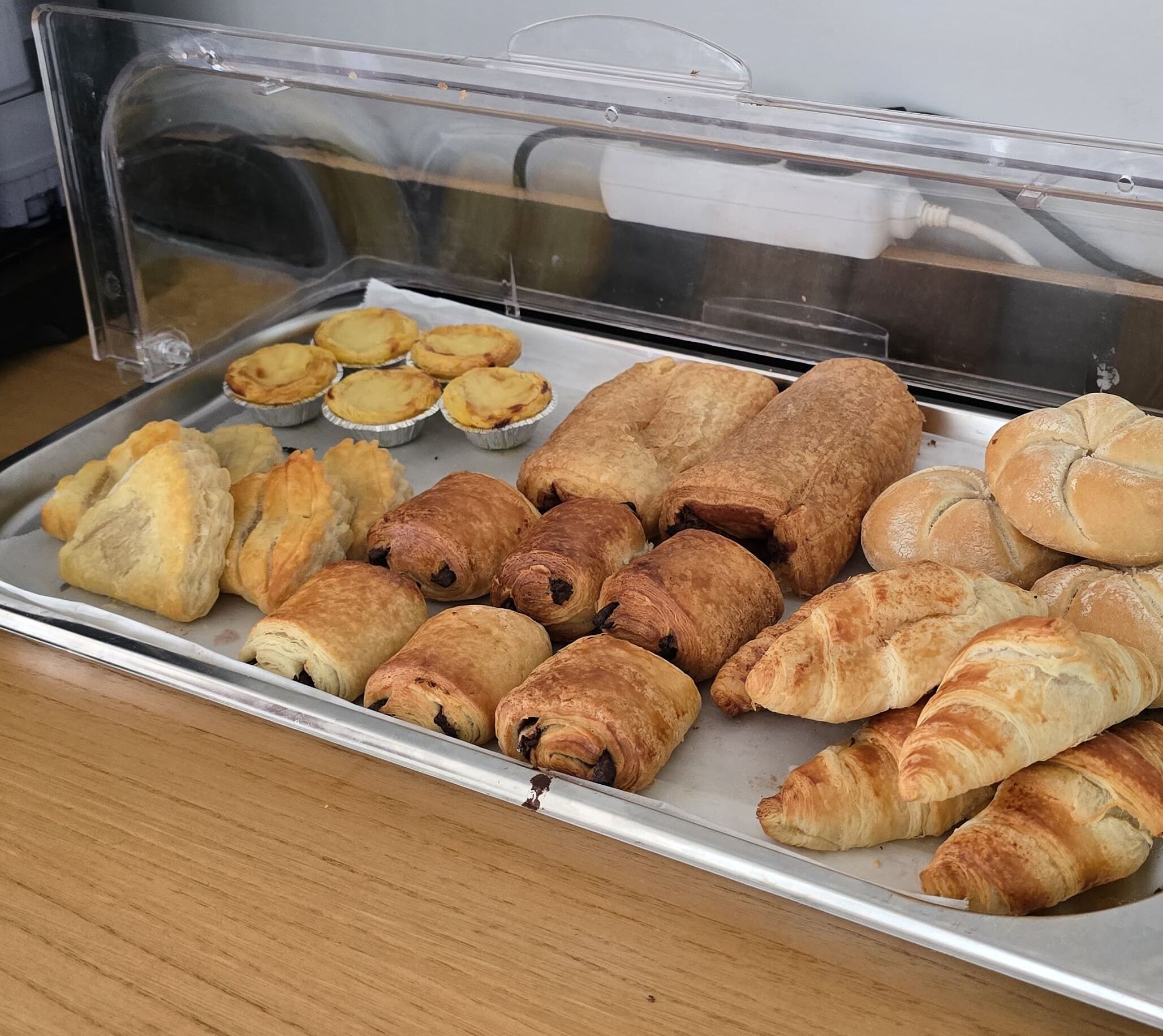A display case with various baked goods including pastries and pies.