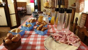 Ein reichhaltiges Frühstücksbuffet mit Brot, Eiern, Schinken und Saft.