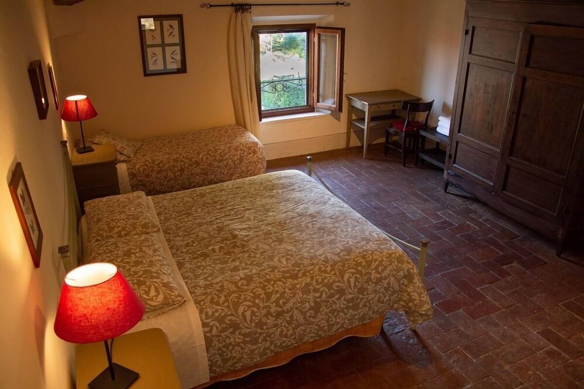 Une chambre avec deux lits, un bureau et une chaise.