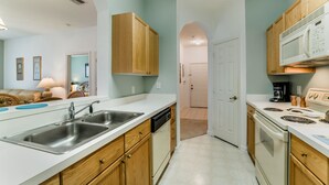 A modern kitchen with wooden cabinets, stainless steel appliances, and a white countertop.