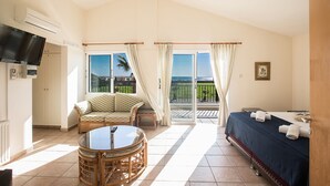 A hotel room with a balcony, a television, a dining table, and a bed. - Luxury 4 Bedroom Villa With Private Pool, Sotira Villa 1301 (Sotira)