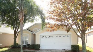 A residential house with a garage, a driveway, and two trees. - Beautiful Villa With Private Pool, Close to Disney, Orlando Villa 1262 (Kissimmee)