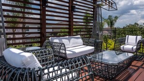 A covered outdoor seating area with wicker furniture and a glass table. - Beautiful Villa With Private Pool, Close to Disney, Orlando Villa 2942 (Kissimmee)