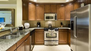 A modern kitchen with wooden cabinets, stainless steel appliances, and granite countertops.