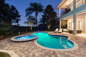 A swimming pool with a curved design, surrounded by a paved patio. - Rent a Luxury Villa on Reunion Resort, Minutes From Disney, Orlando Villa 3539 (Kissimmee)