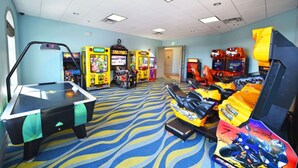 A room with arcade games, a pool table, and a large screen. - Luxury 5 Bedroom Villa on Champions Gate Resort, Orlando Villa 2525 (Davenport)