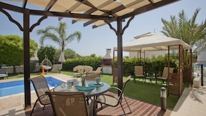 A covered outdoor area with a pool, a table with chairs, and a gazebo. - Cyprus Villa Near the Beach, Sotira Villa 1001 (Sotira)