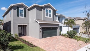 A two-story house with a garage, a driveway, and a well-maintained lawn. - Villa in Encore Resort at Reunion 3438 (Kissimmee)