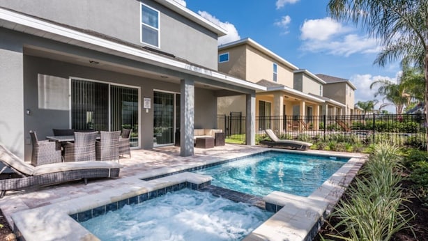 A residential building with a swimming pool, outdoor seating, and a covered patio area. - Villa in Encore Resort at Reunion 3438 (Kissimmee)