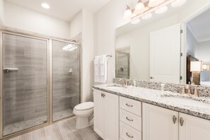 A modern bathroom with a glass-enclosed shower, a white toilet, and a granite countertop with a mirror. - Beautiful Mansion With Private Pool, Close to Disney, Orlando Mansion 2889 (Kissimmee)
