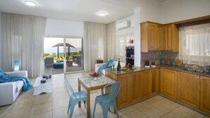 Une cuisine moderne avec des meubles en bois et un coin repas comprenant une table et des chaises.