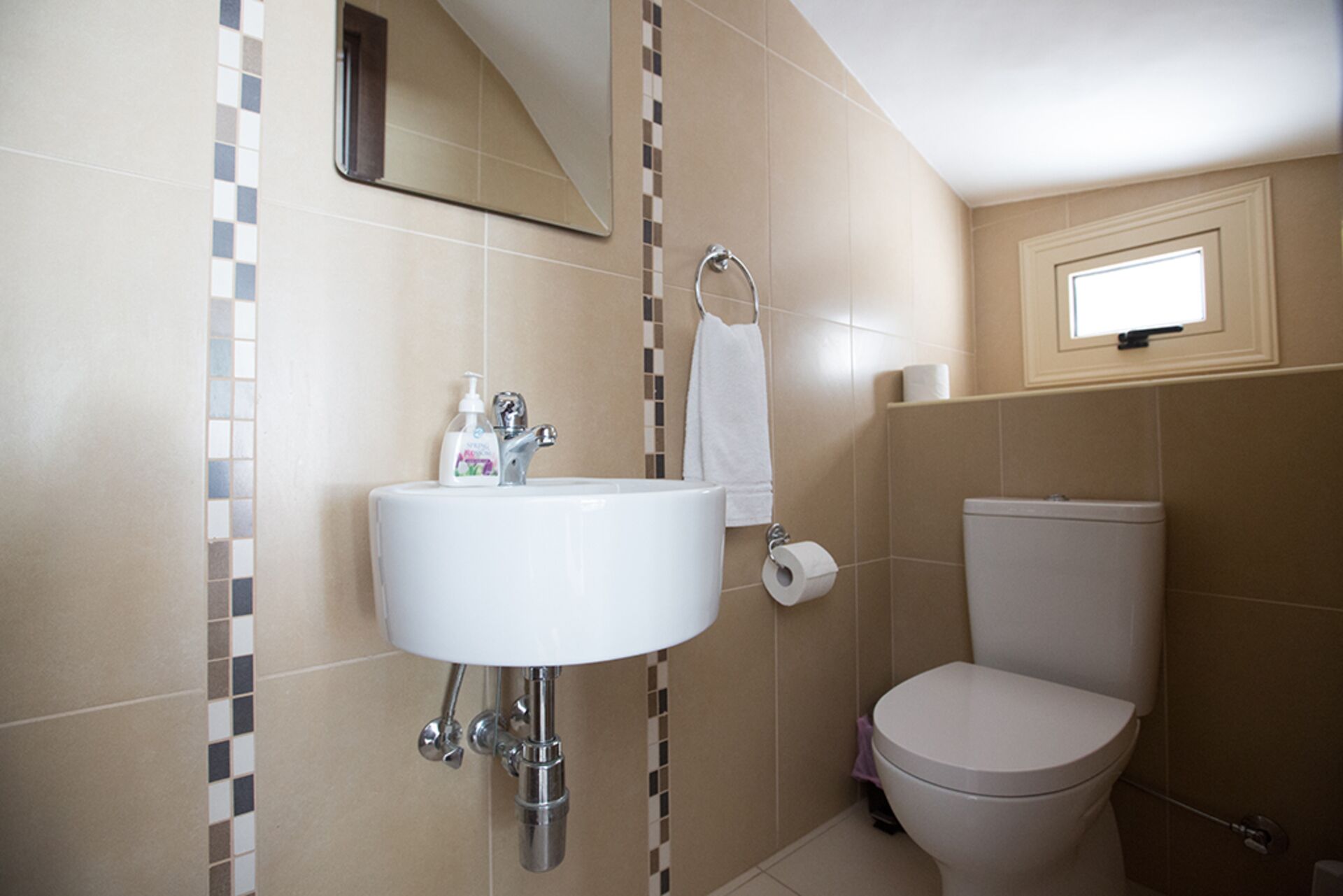 A bathroom with a white sink, a toilet, and a mirror.