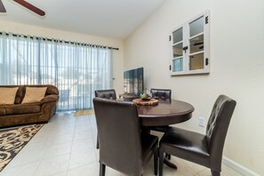 A dining area with a round table, four chairs, and a decorative bowl. - Luxury 3 Bedroom House on Windsor Hills Resort, Orlando House 1902 (Kissimmee)