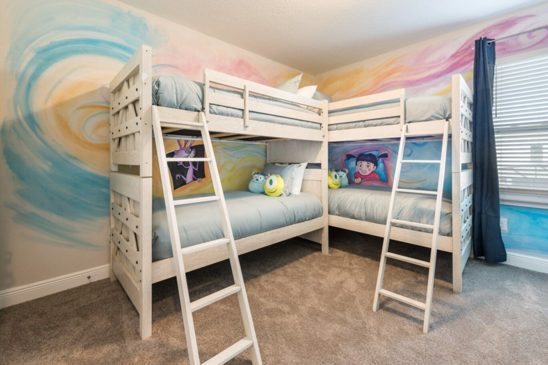 A bunk bed room with a colorful mural, a window with blinds, and a carpeted floor.