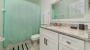 Ein Badezimmer mit Toilette, Waschbecken und Duschvorhang.