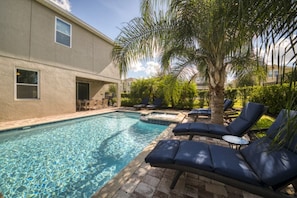 A swimming pool with lounge chairs and a patio area.