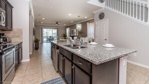 A modern kitchen with granite countertops, stainless steel appliances, and a large island. - Beautiful Villa With Private Pool, Close to Disney, Orlando Villa 2641 (Kissimmee)