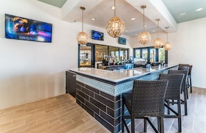 Enjoy a drink at the bar, surrounded by lush views and comfortable seating.