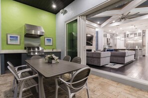 Uma sala de estar integrada com uma mesa de jantar, cadeiras e um sofá.