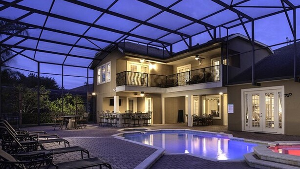 A two-story building with a covered outdoor area, a swimming pool, and outdoor seating. - Luxury 9 Bedroom Villa on Osceola County, Orlando Villa 3569 (Kissimmee)